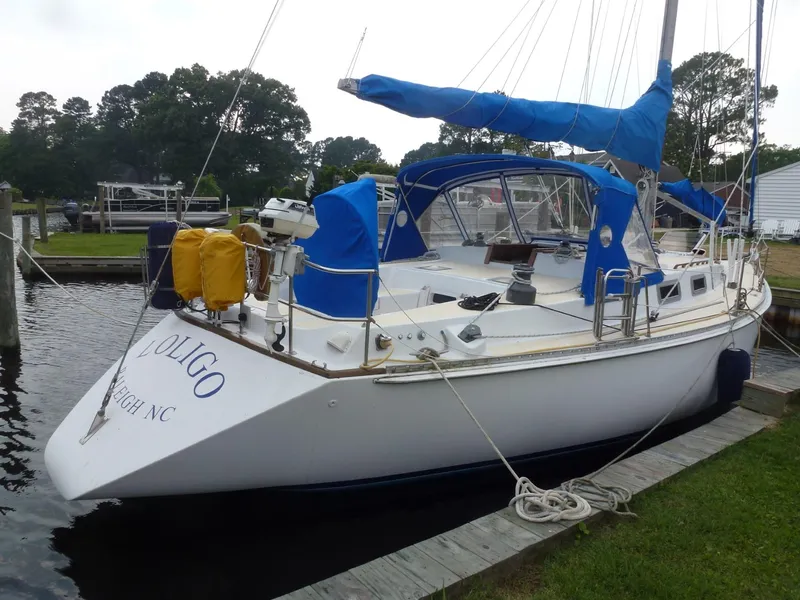 Slide: The Image of 1984 Morgan 454 sailboat docked with blue covers. - 7