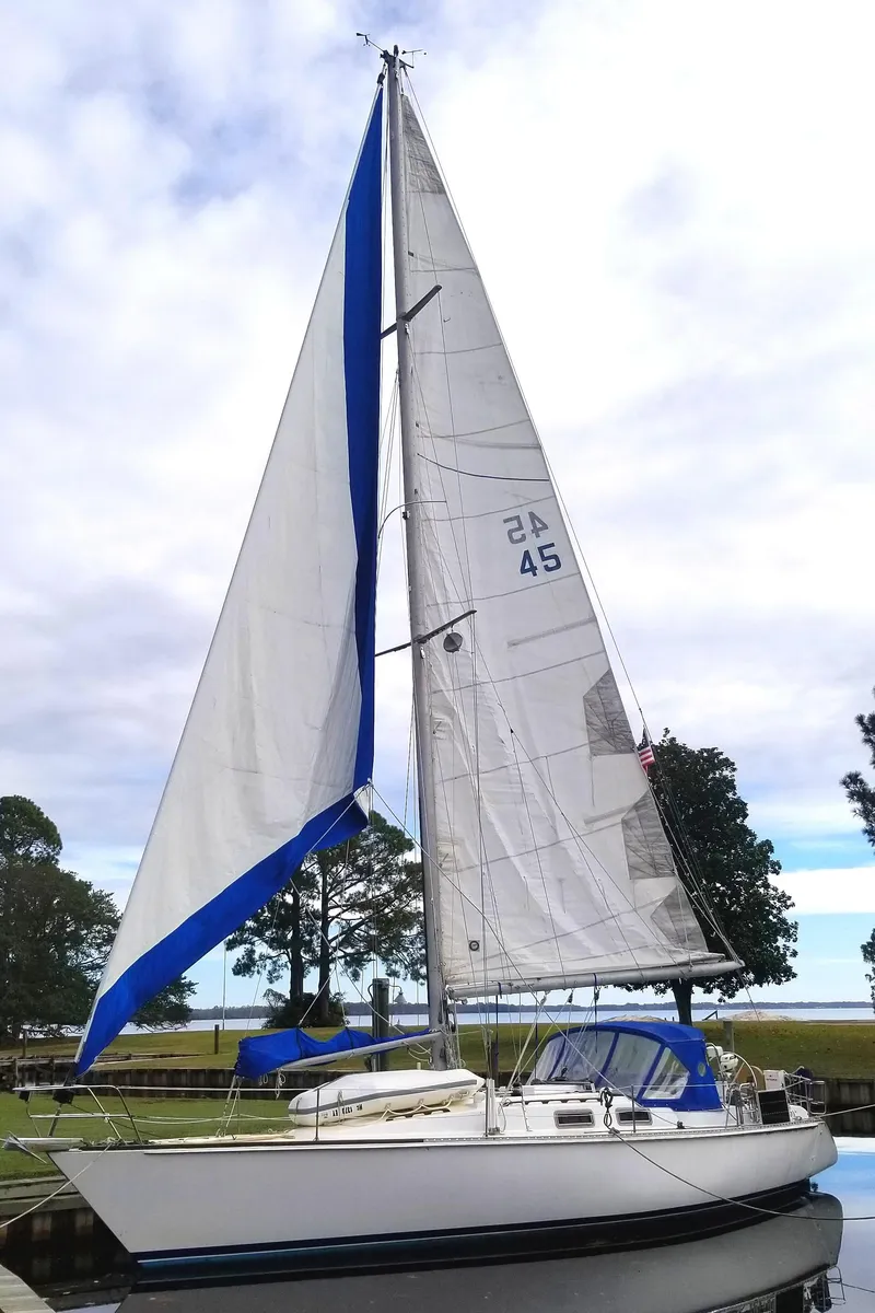 Slide: The Image of 1984 Morgan 454 sailboat with white sails and blue accents. - 8