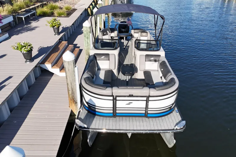 Slide: The Image of 2023 Starcraft MX 25 R DC pontoon boat docked on calm water. - 3