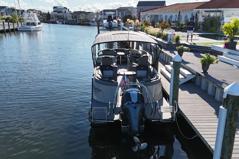 Slide: The Image of 2023 Starcraft MX 25 R DC pontoon boat docked in a scenic marina. - 5