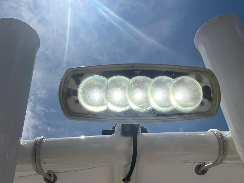 Slide: The Image of LED light on a 2020 Cobia 220 boat under a bright blue sky. - 12