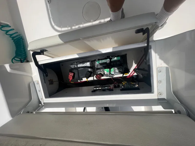 Slide: The Image of Open battery compartment on a 2020 Cobia 220 boat, showing wiring and connections. - 18