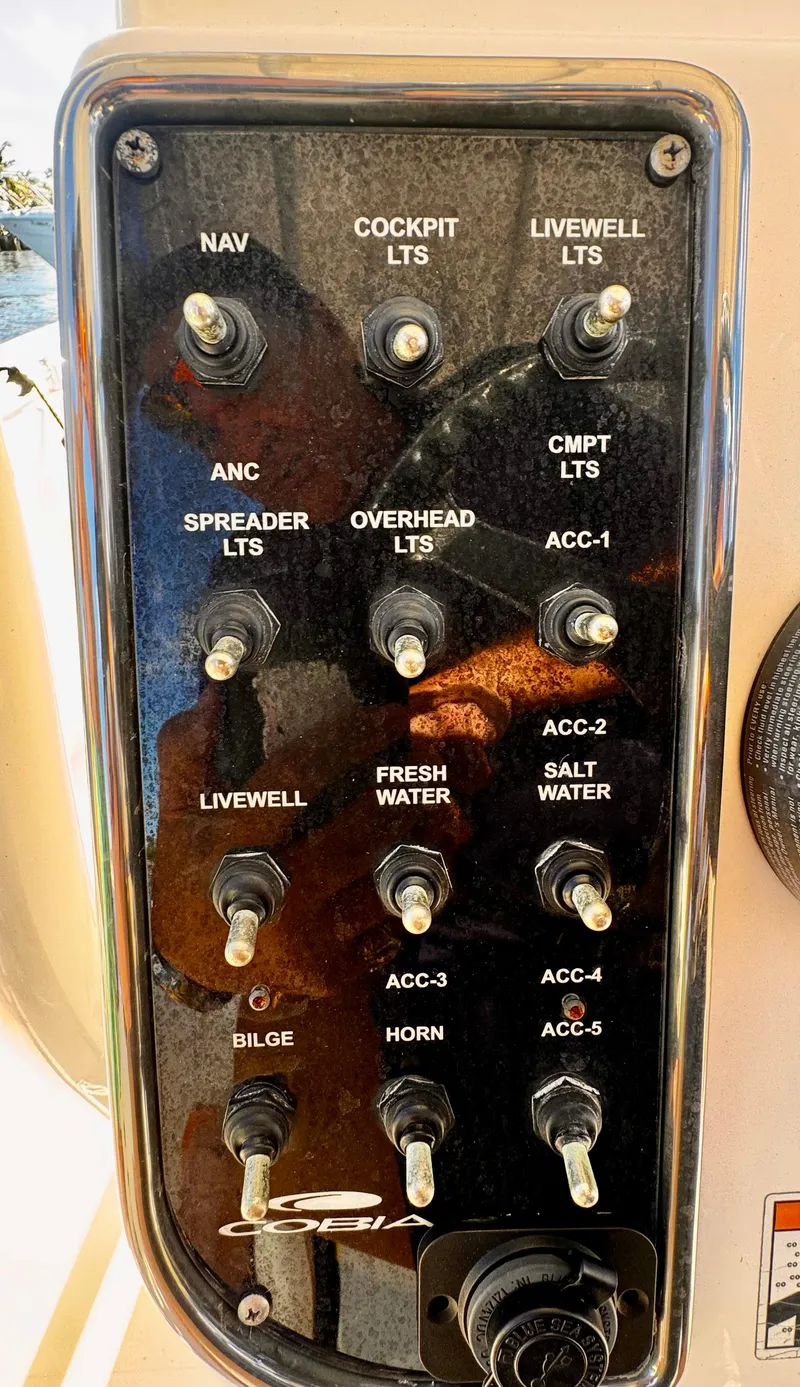 Slide: The Image of Control panel of a 2020 Cobia 220 boat with various switches and labels. - 23