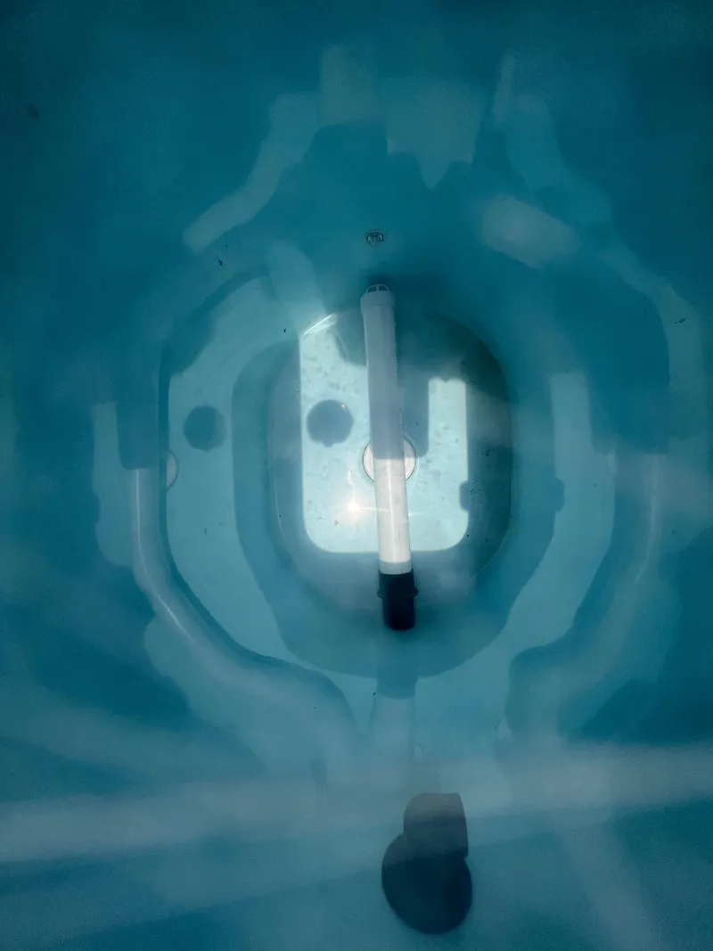 Slide: The Image of Interior view of a 2020 Cobia 220 boat's livewell, showing water and plumbing. - 26