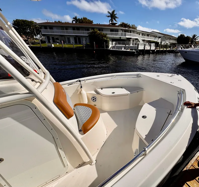 Slide: The Image of 2020 Cobia 220 boat docked by waterfront homes under a clear blue sky. - 3