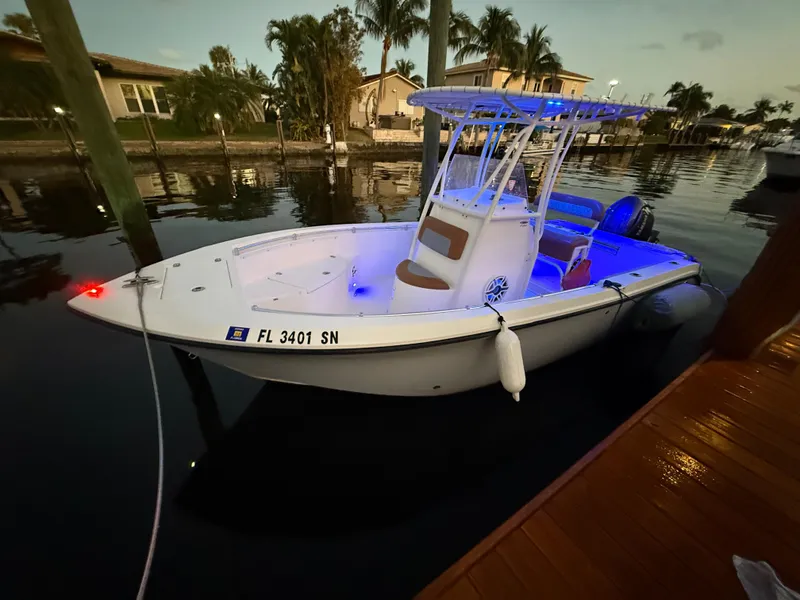 Slide: The Image of 2020 Cobia 220 boat docked at sunset with blue interior lights. - 38