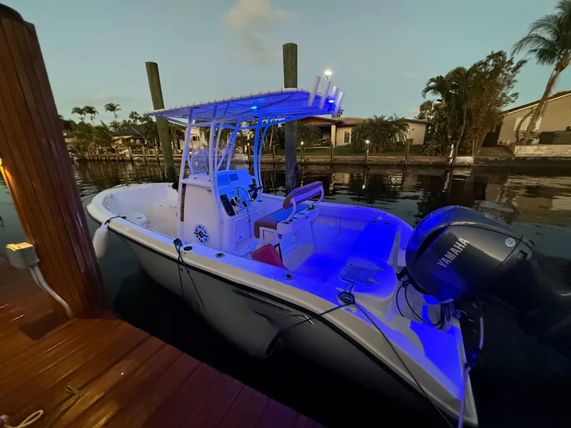 Slide: The Image of Sure, the image shows a 2020 Cobia 220 boat with a Yamaha engine, docked near a waterfront. - 39