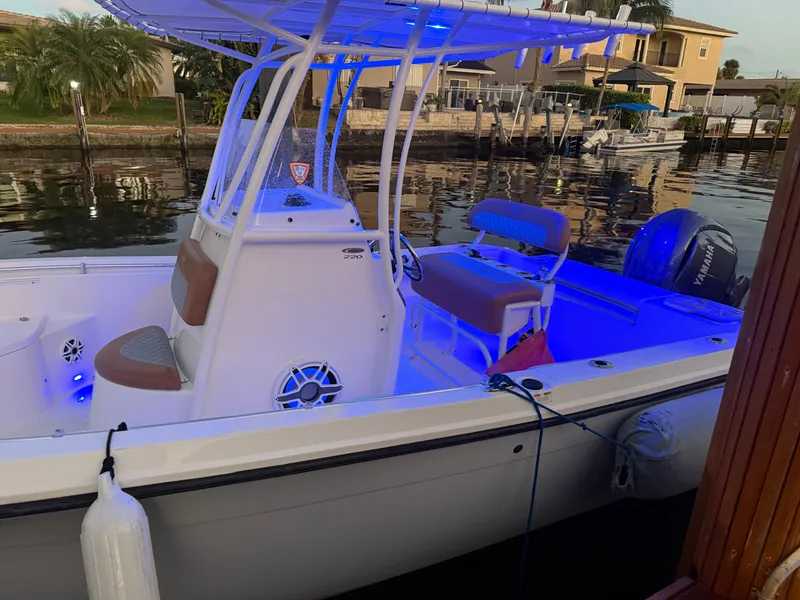 Slide: The Image of 2020 Cobia 220 boat docked, featuring blue LED lights and a sleek design. - 40
