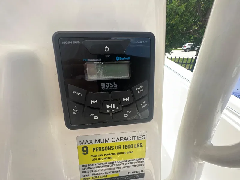Slide: The Image of Boat stereo system and capacity label on 2020 Cobia 220, max 9 persons or 1600 lbs. - 8