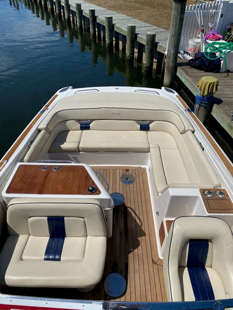 Slide: The Image of 2004 Chris-Craft Corsair 28 boat with beige and blue seating, docked by a pier. - 1