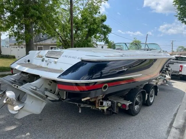 Slide: The Image of 2004 Chris-Craft Corsair 28 boat on a trailer, parked on a residential street. - 12