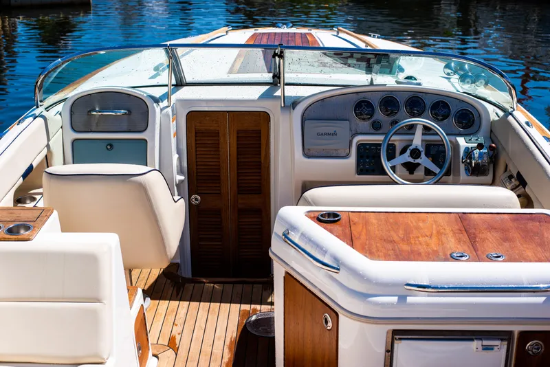Slide: The Image of 2004 Chris-Craft Corsair 28 boat interior with wooden accents and steering console. - 3