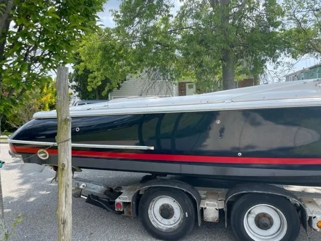 Slide: The Image of 2004 Chris-Craft Corsair 28 boat on a trailer, parked outdoors. - 9