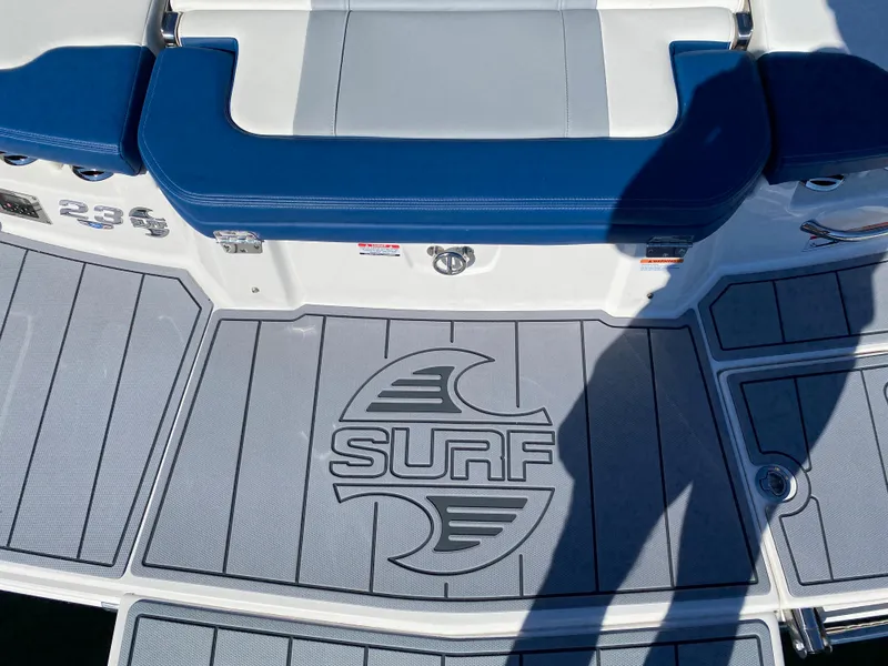 Slide: The Image of 2022 Chaparral 23 SSi boat deck with Surf logo and cushioned seating. - 12