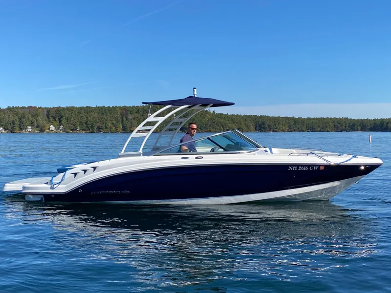 Slide: The Image of 2022 Chaparral 23 SSi boat cruising on a lake with a person at the helm. - 18