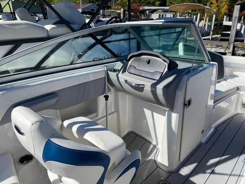 Slide: The Image of 2022 Chaparral 23 SSi boat interior with white and blue seating, and modern dashboard. - 8