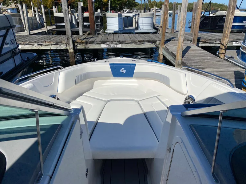 Slide: The Image of 2022 Chaparral 23 SSi boat docked at a marina, front seating area view. - 9