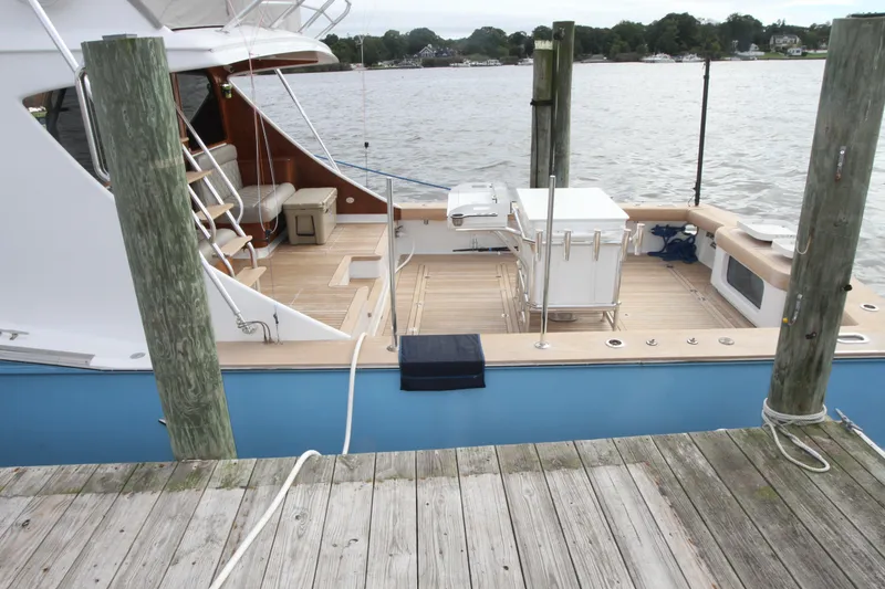 Slide: The Image of Custom Carolina Ritchie Howell 60 Sportfish 2012 docked, showcasing spacious deck and fishing equipment. - 41