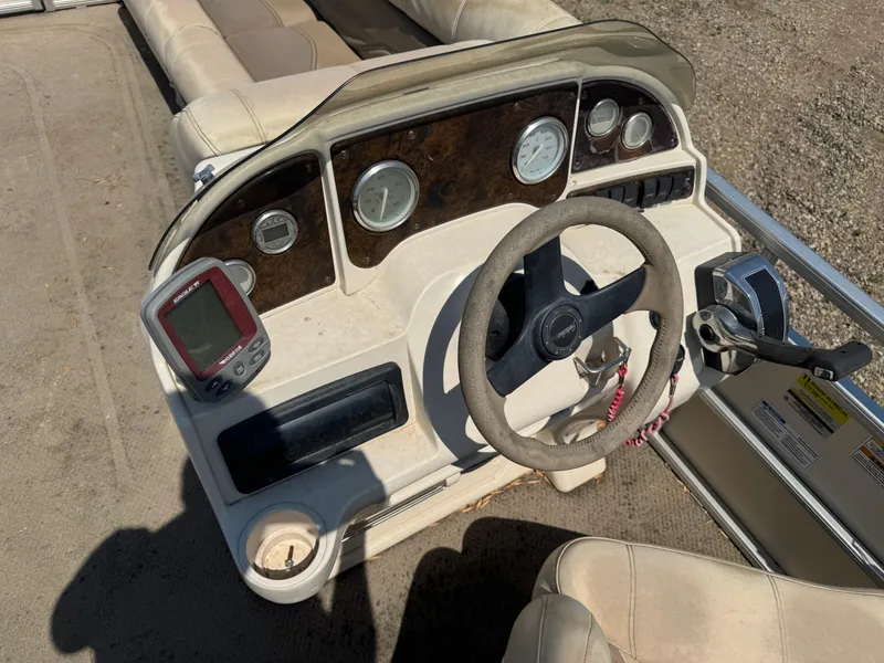 Slide: The Image of Steering console of a 2004 Godfrey SweetWater 2019SC pontoon boat with gauges and controls. - 9