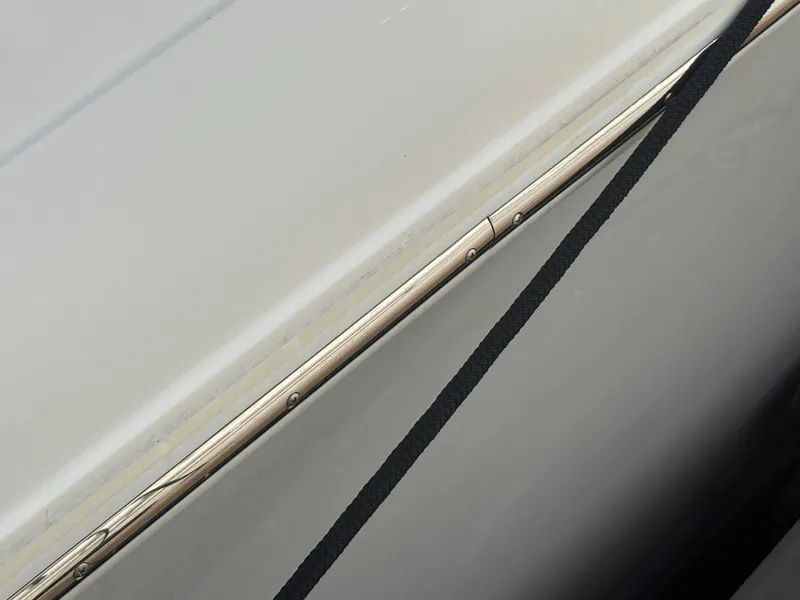 Slide: The Image of Close-up of 2022 Cobalt 30SC boat hull with sleek design and black strap. - 12