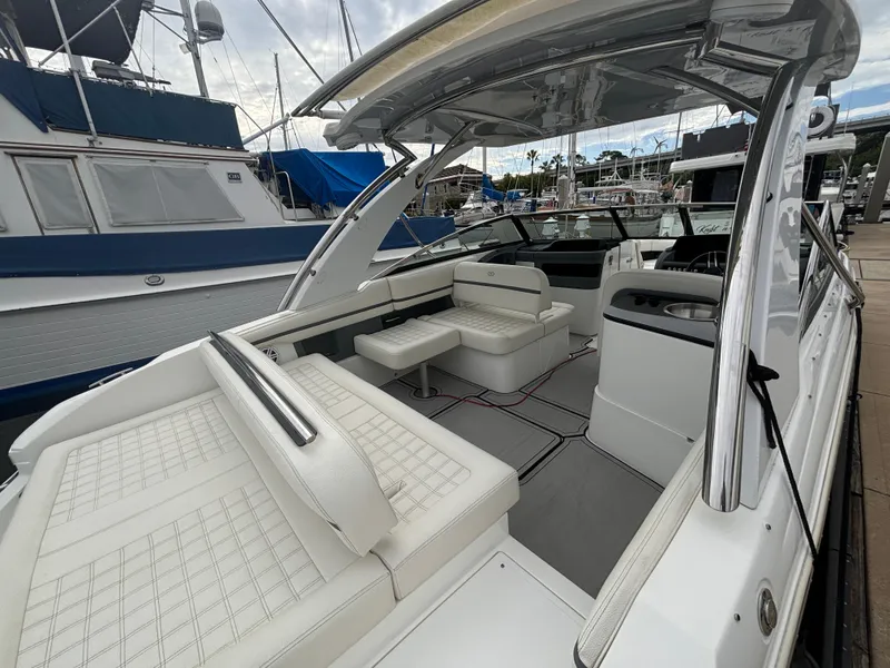 Slide: The Image of 2022 Cobalt 30SC boat with spacious white seating and sleek design at marina. - 16