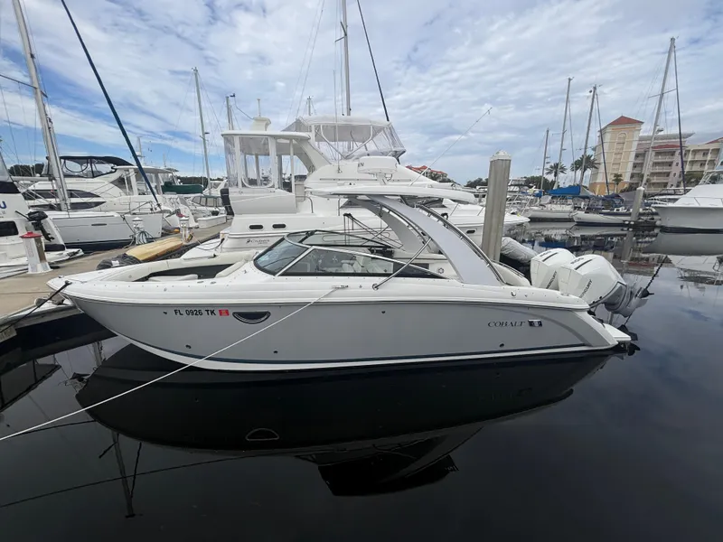 Slide: The Image of 2022 Cobalt 30SC boat docked in marina, surrounded by other vessels. - 2