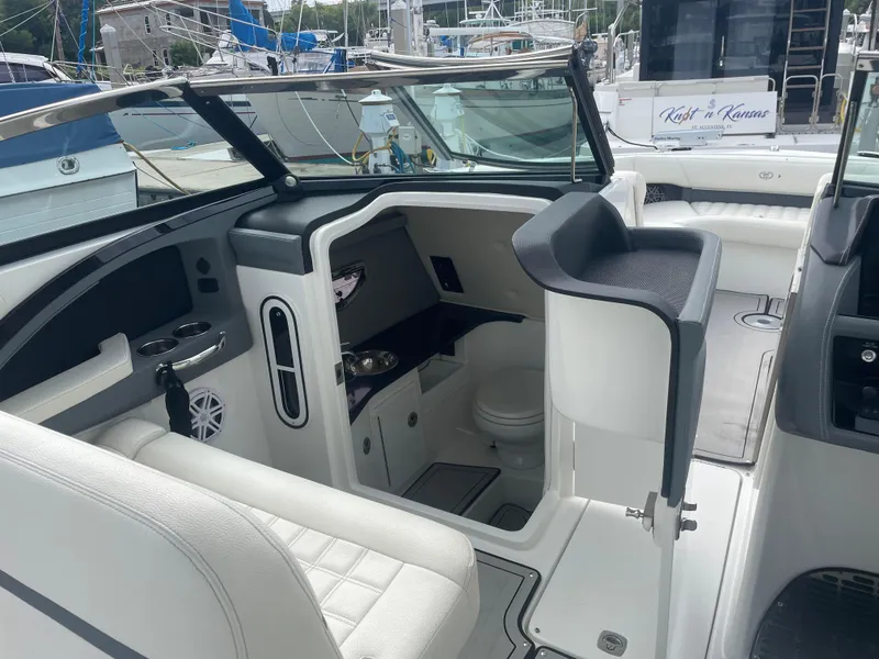 Slide: The Image of 2022 Cobalt 30SC boat interior with seating and helm, docked at marina. - 23