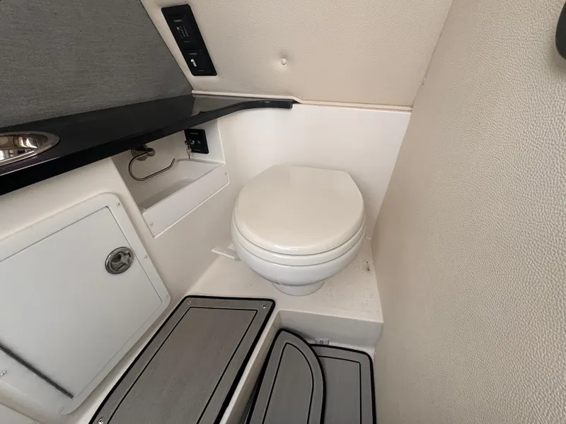 Slide: The Image of 2022 Cobalt 30SC boat interior bathroom with toilet and storage compartments. - 26