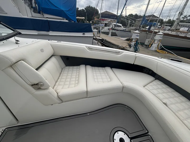 Slide: The Image of 2022 Cobalt 30SC boat with white leather seating in a marina. - 30
