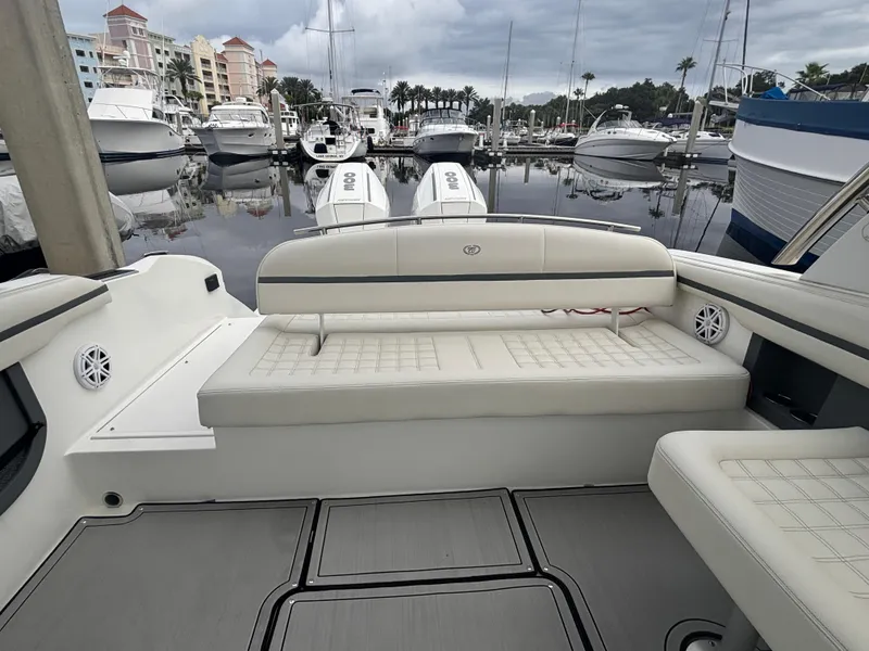 Slide: The Image of 2022 Cobalt 30SC boat interior with white seating at marina. - 44