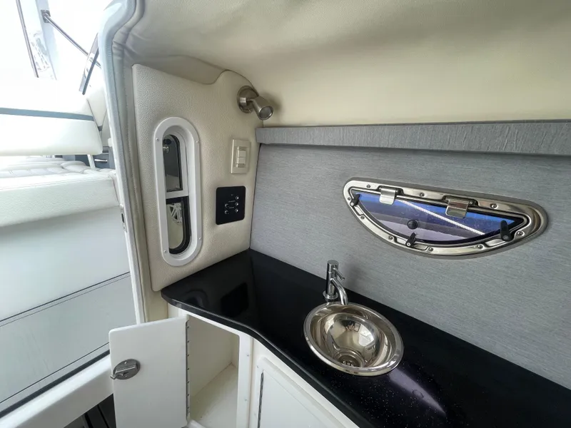 Slide: The Image of 2022 Cobalt 30SC boat interior with sink and porthole window. - 48