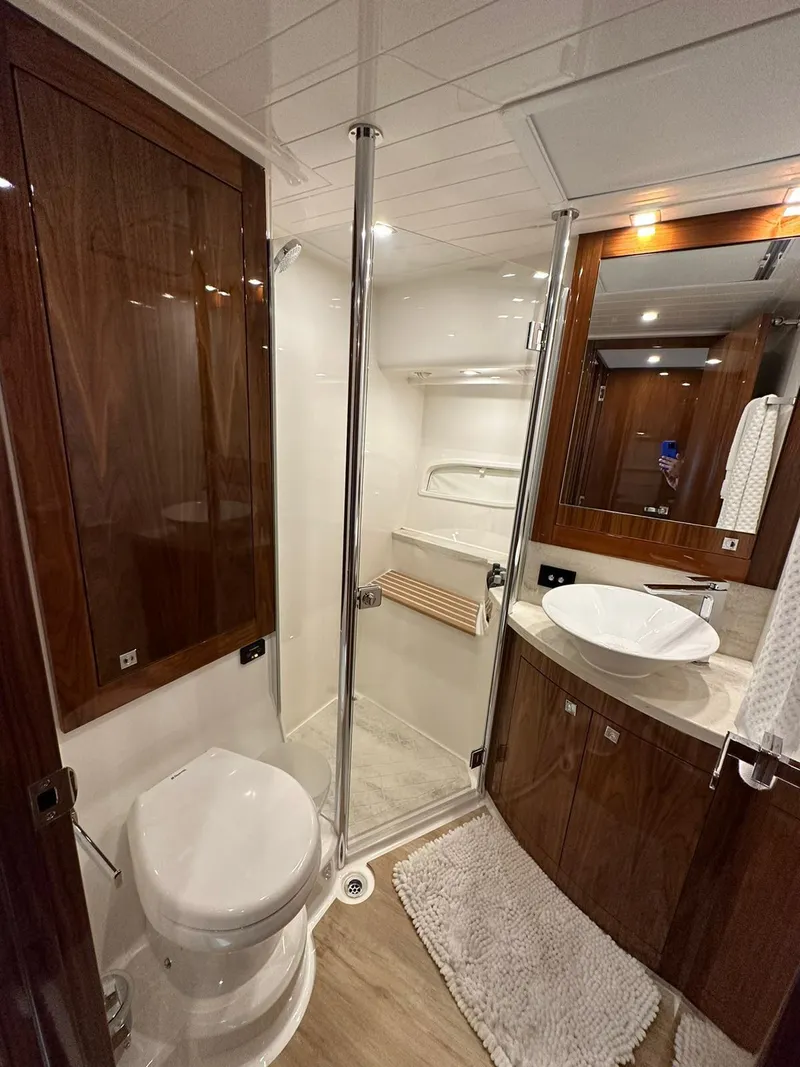Slide: The Image of Luxurious bathroom in 2018 Riviera 60SY yacht with modern fixtures and elegant wood finishes. - 16