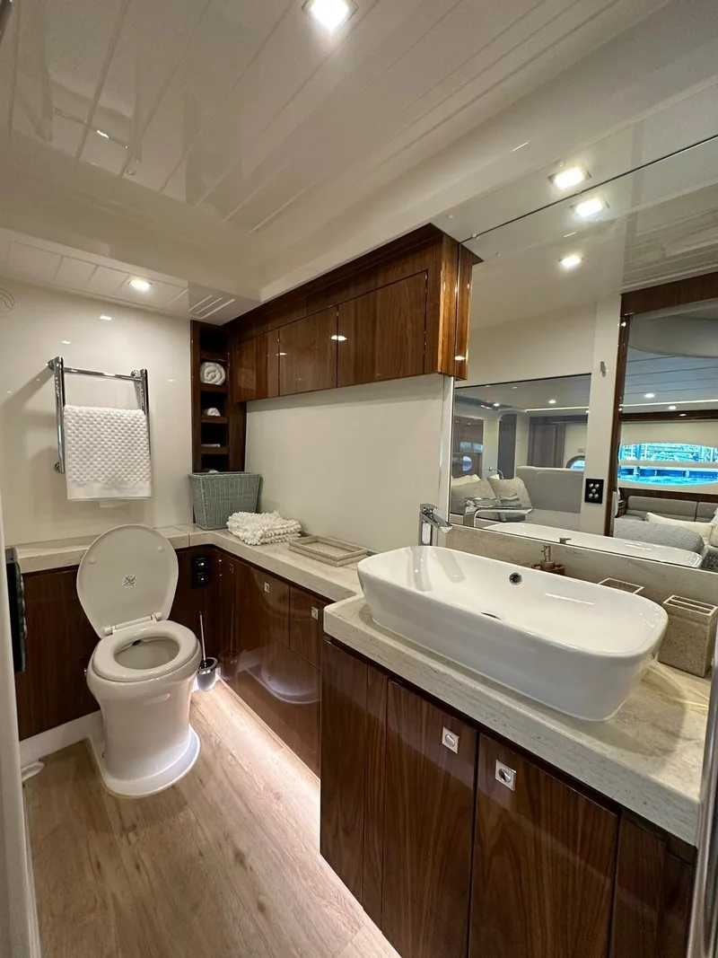 Slide: The Image of Luxurious bathroom in 2018 Riviera 60SY yacht with modern fixtures and wooden cabinetry. - 17