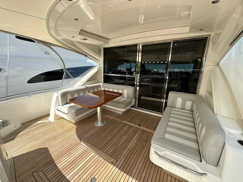 Slide: The Image of Luxurious 2018 Riviera 60SY yacht deck with elegant seating and wooden table. - 2