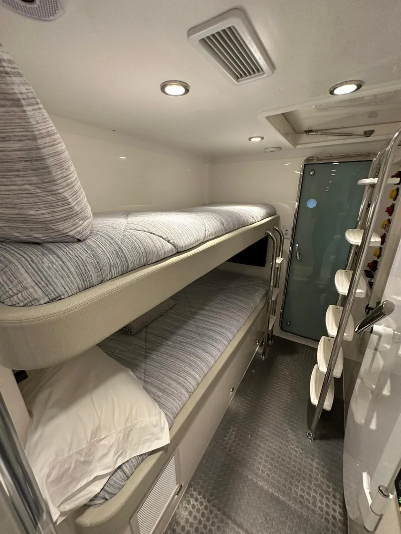 Slide: The Image of Bunk beds in 2018 Riviera 60SY yacht cabin with modern lighting and sleek design. - 22