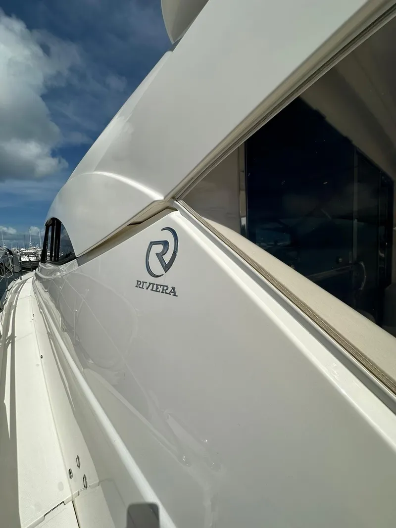 Slide: The Image of Riviera 60SY 2018 yacht side view with logo under a blue sky. - 4