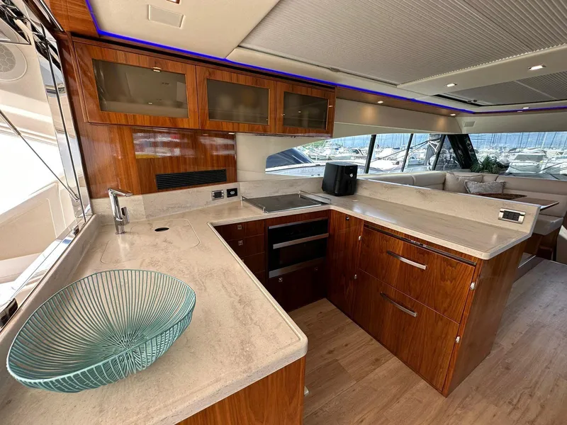 Slide: The Image of Luxurious kitchen interior of 2018 Riviera 60SY yacht with modern wood cabinetry and sleek countertops. - 5