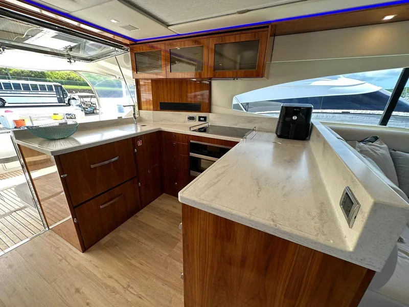 Slide: The Image of Luxurious kitchen interior of 2018 Riviera 60SY yacht with modern wood cabinetry and sleek countertops. - 6