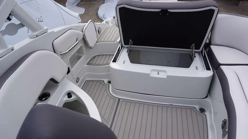 Slide: The Image of 2024 Crownline 260 XS boat interior with open storage compartment and seating area. - 2