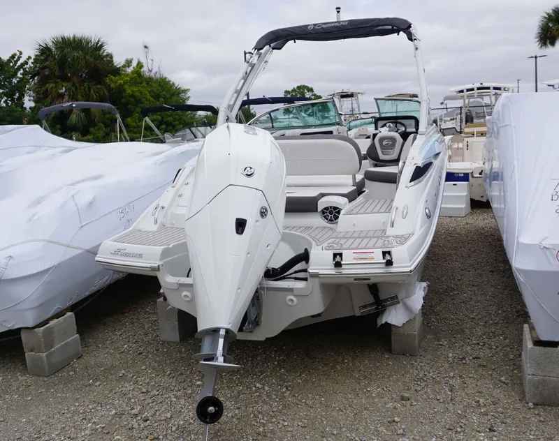 Slide: The Image of 2024 Crownline 260 XS boat with outboard motor in a marina. - 22