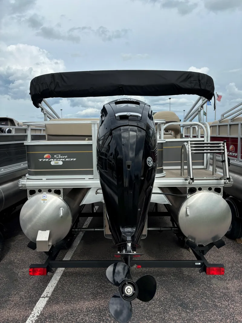 Slide: The Image of 2023 Sun Tracker Party Barge 18 DLX pontoon boat, rear view with outboard motor. - 2