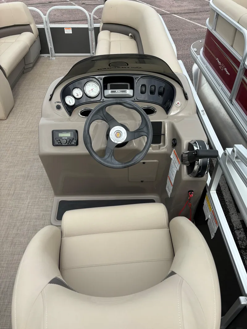 Slide: The Image of 2023 Sun Tracker Party Barge 18 DLX pontoon boat helm with beige seating and control panel. - 3