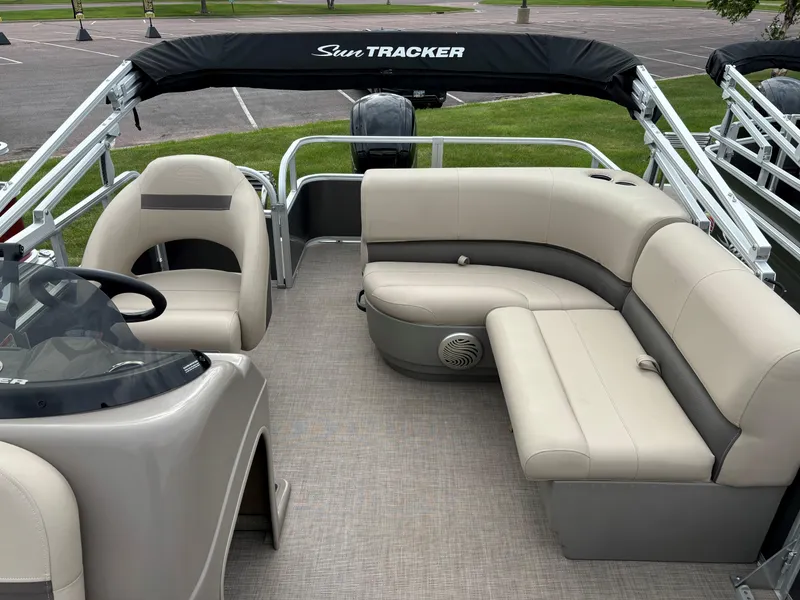 Slide: The Image of 2023 Sun Tracker Party Barge 18 DLX interior with beige seating and black canopy. - 6