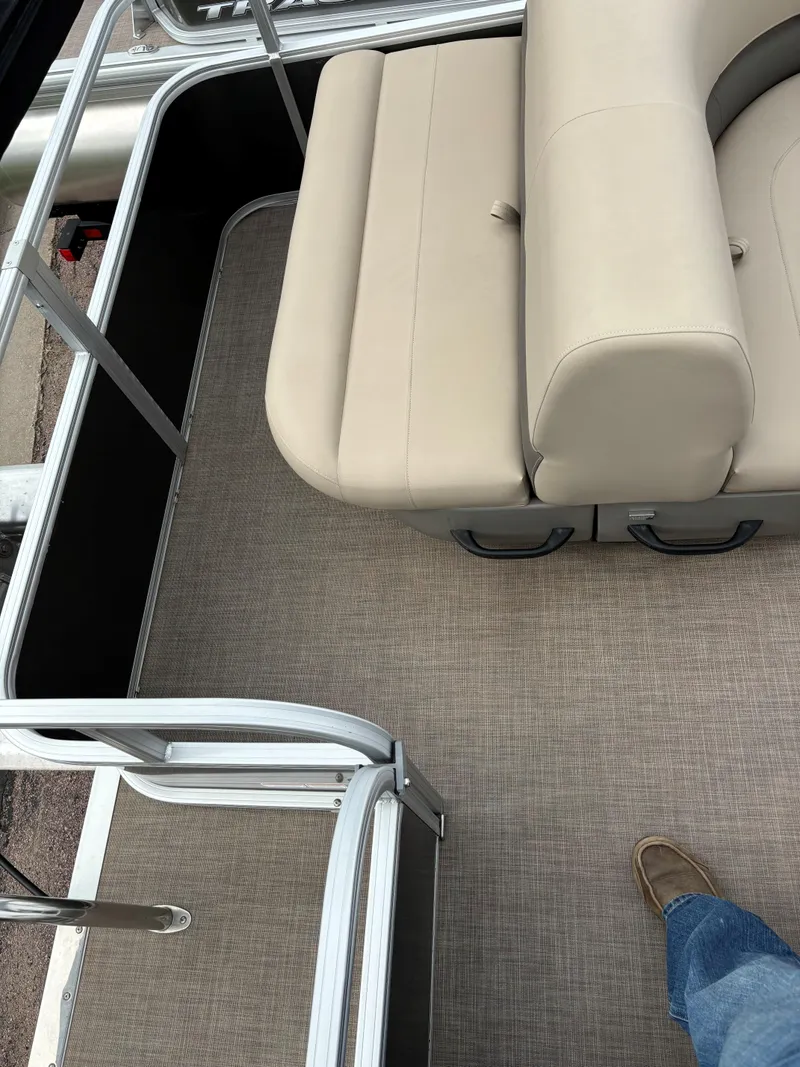 Slide: The Image of 2023 Sun Tracker Party Barge 18 DLX interior with beige seating and carpeted floor. - 7