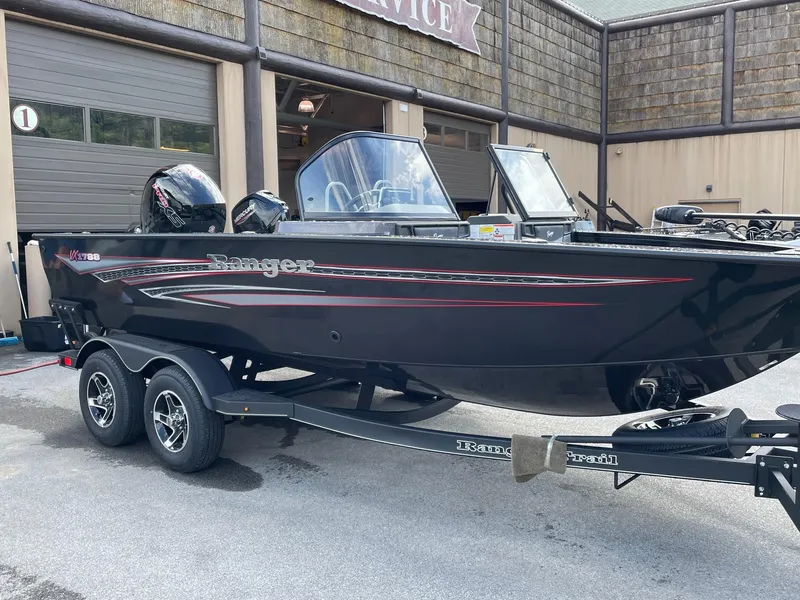 Slide: The Image of 2023 Ranger VX1788 WT fishing boat on a trailer outside a service garage. - 6