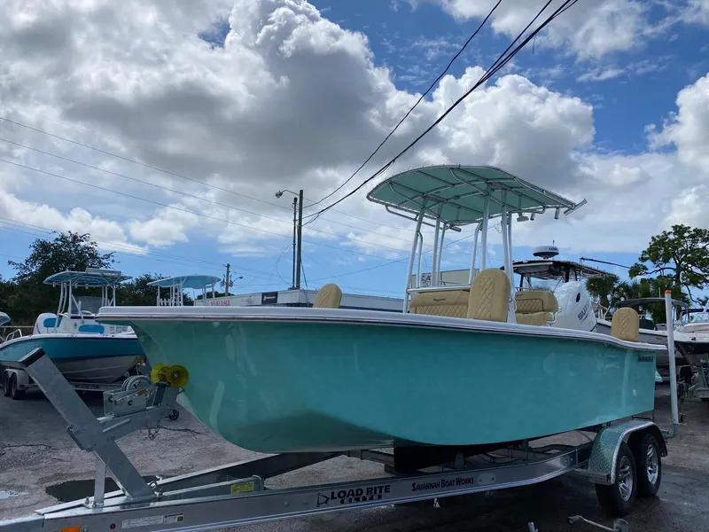 Slide: The Image of 2023 Savannah SS21 boat on a trailer under a cloudy sky. - 2