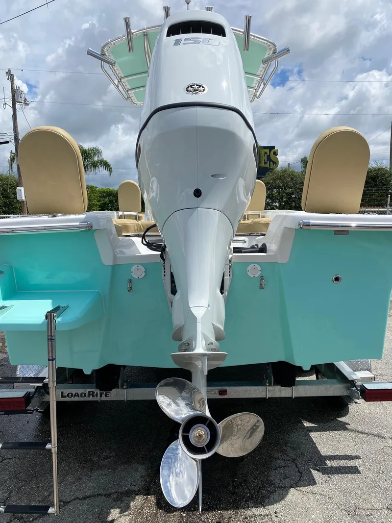 Slide: The Image of 2023 Savannah SS21 boat rear view with outboard motor and teal hull. - 31
