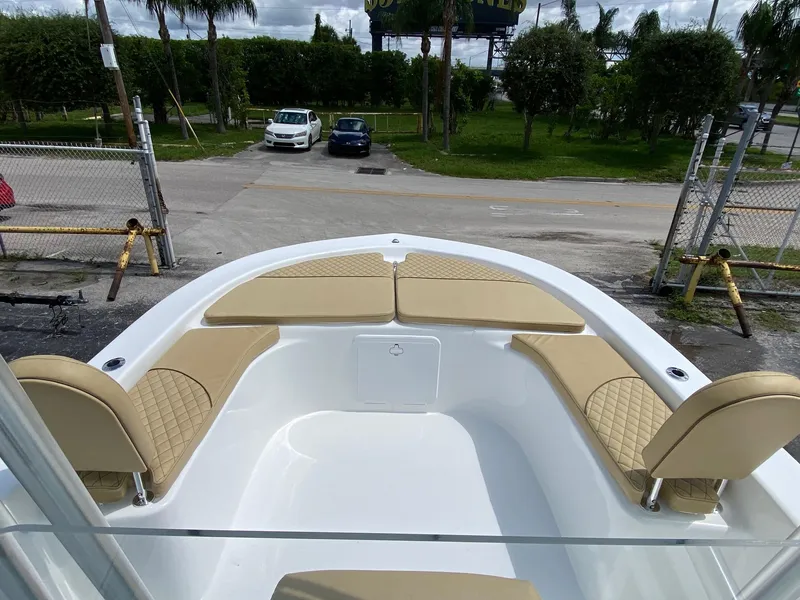 Slide: The Image of 2023 Savannah SS21 boat with beige seating at the bow, parked near a gate. - 6