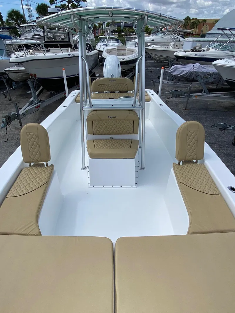 Slide: The Image of 2023 Savannah SS21 boat with tan seating, docked among other boats. - 8