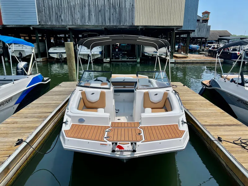 Slide: The Image of 2023 Starcraft SVX 210 IO boat docked at marina. - 2